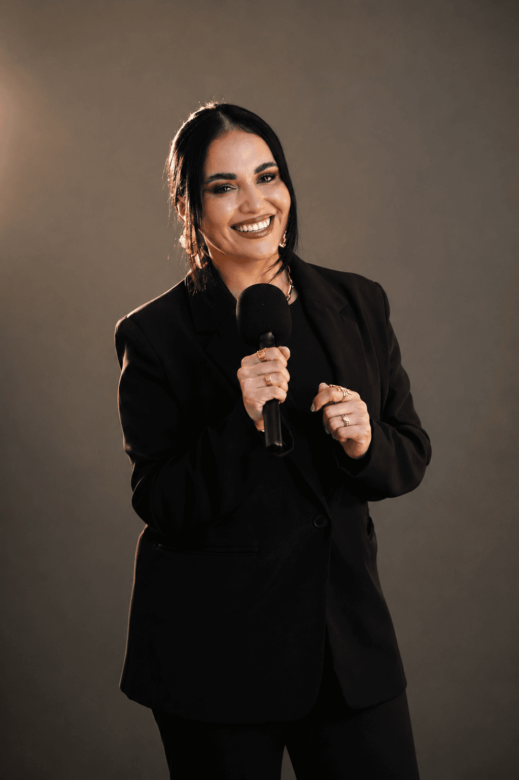 Dr. Gissele Donovan — smiling with microphone, editorial portrait
